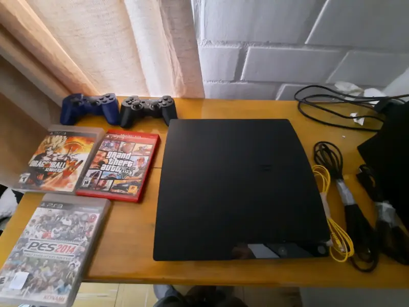 PlayStation 3 con juegos y controles - 1