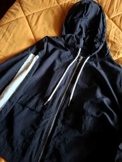 Chaqueta cortaviento negra con capucha - miniatura 1