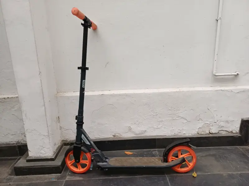 Scooter negro con ruedas naranjas