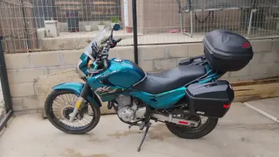 Moto de turismo azul con maletas - miniatura 1