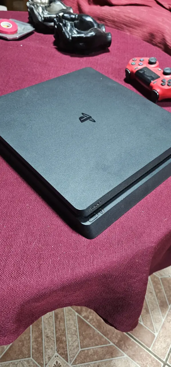 Consola PlayStation negra con control - 1