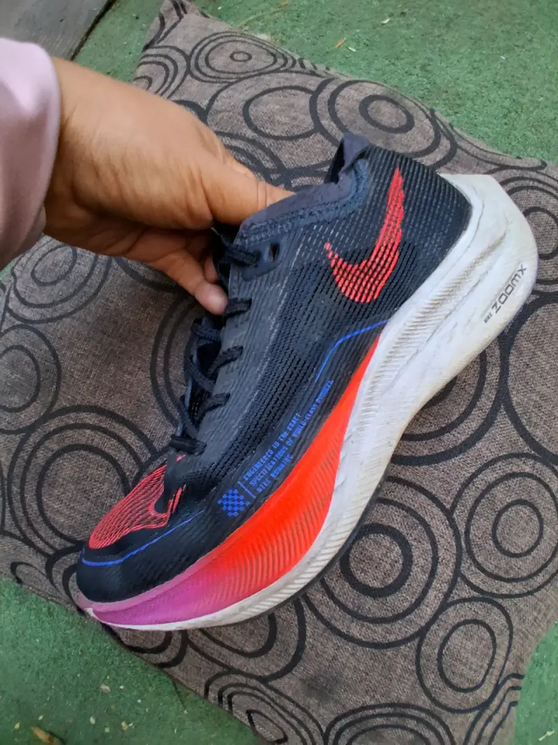 Zapatilla deportiva negra con logo rojo
