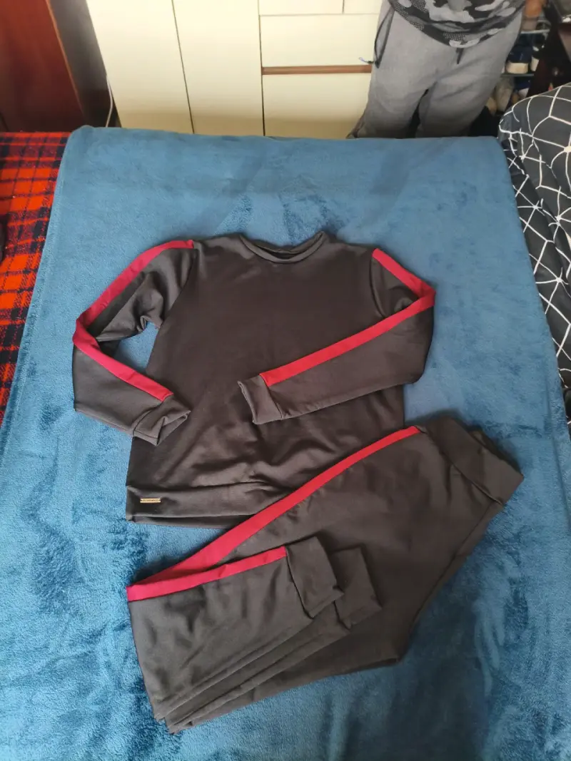Conjunto deportivo negro con franjas rojas