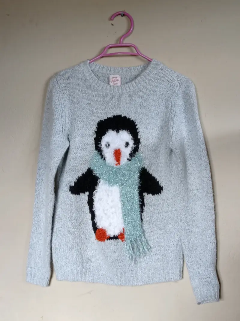 Suéter gris con pingüino brillante