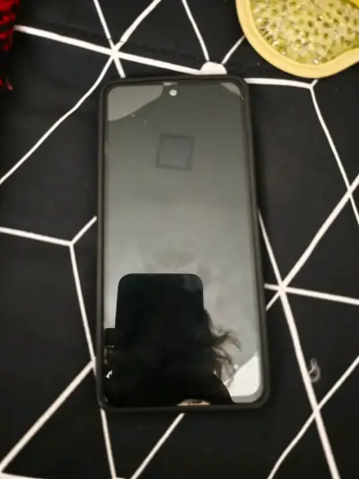 Smartphone en carcasa negra - miniatura 1