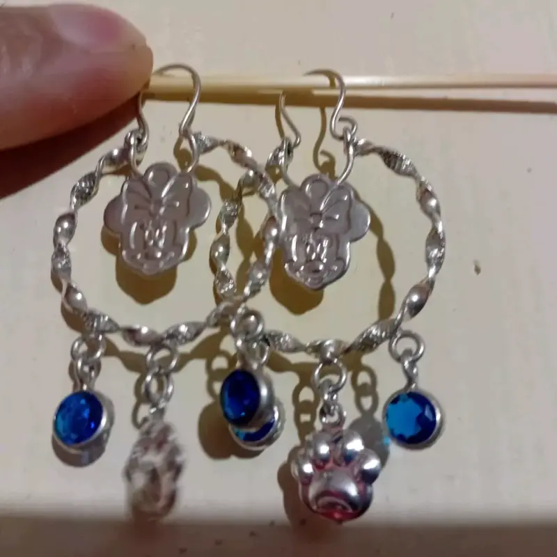 Aros colgantes plateados con dijes