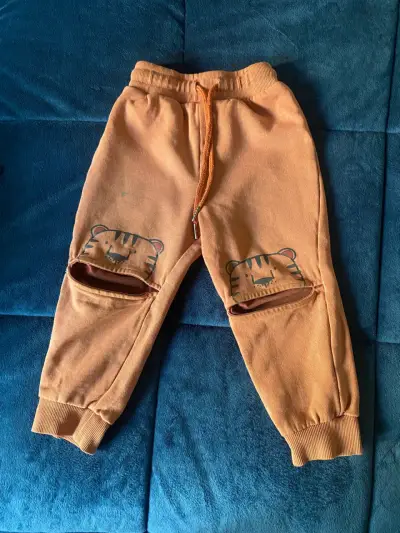 Pantalones infantiles naranjas con dibujos - miniatura 1