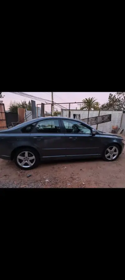 Auto sedán gris oscuro Volvo S40 - miniatura 3