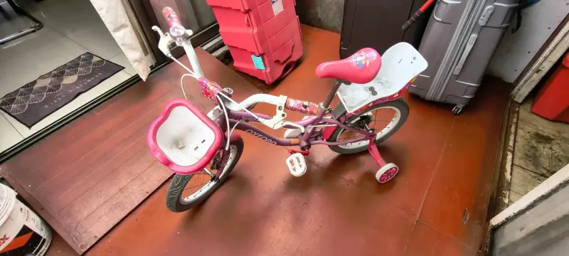 Bicicleta infantil rosada con ruedas auxiliares - 2