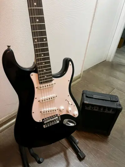Guitarra eléctrica negra con amplificador - miniatura 1