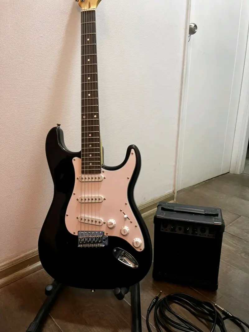 Guitarra eléctrica negra con amplificador - 2