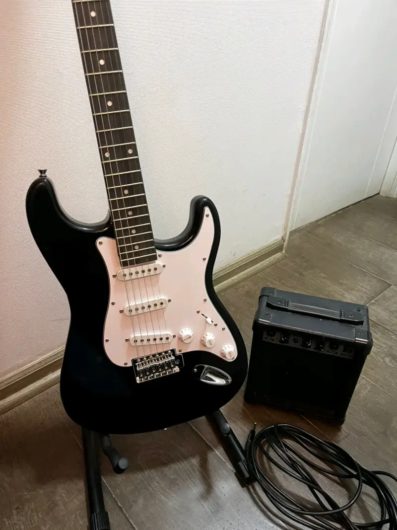 Guitarra eléctrica negra con amplificador - 4