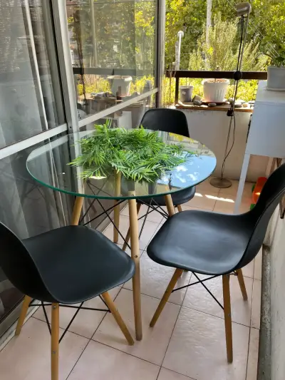 Mesa de vidrio con sillas negras - miniatura 4