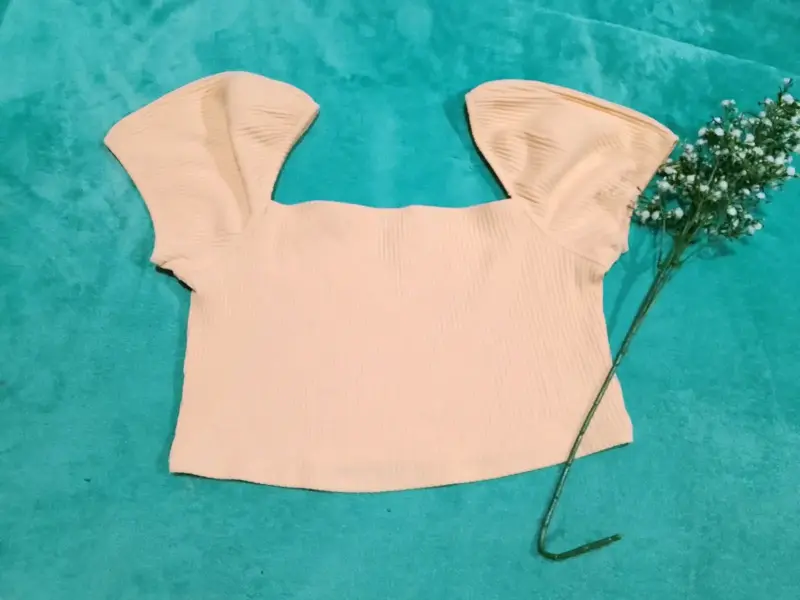 Top corto beige con mangas abullonadas