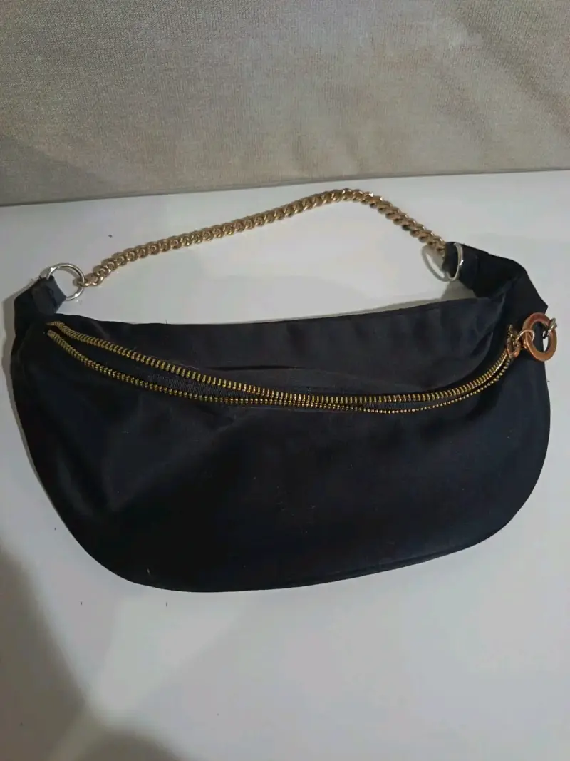 Riñonera negra con cadena dorada