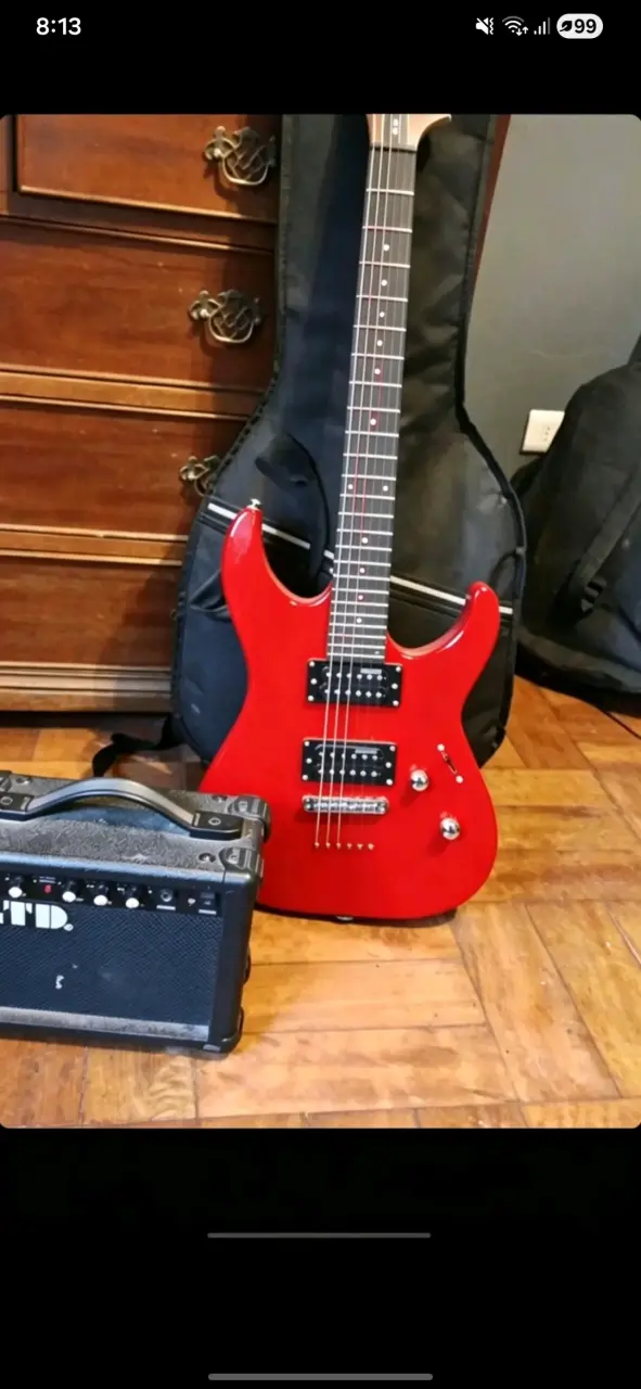 Guitarra eléctrica roja con amplificador