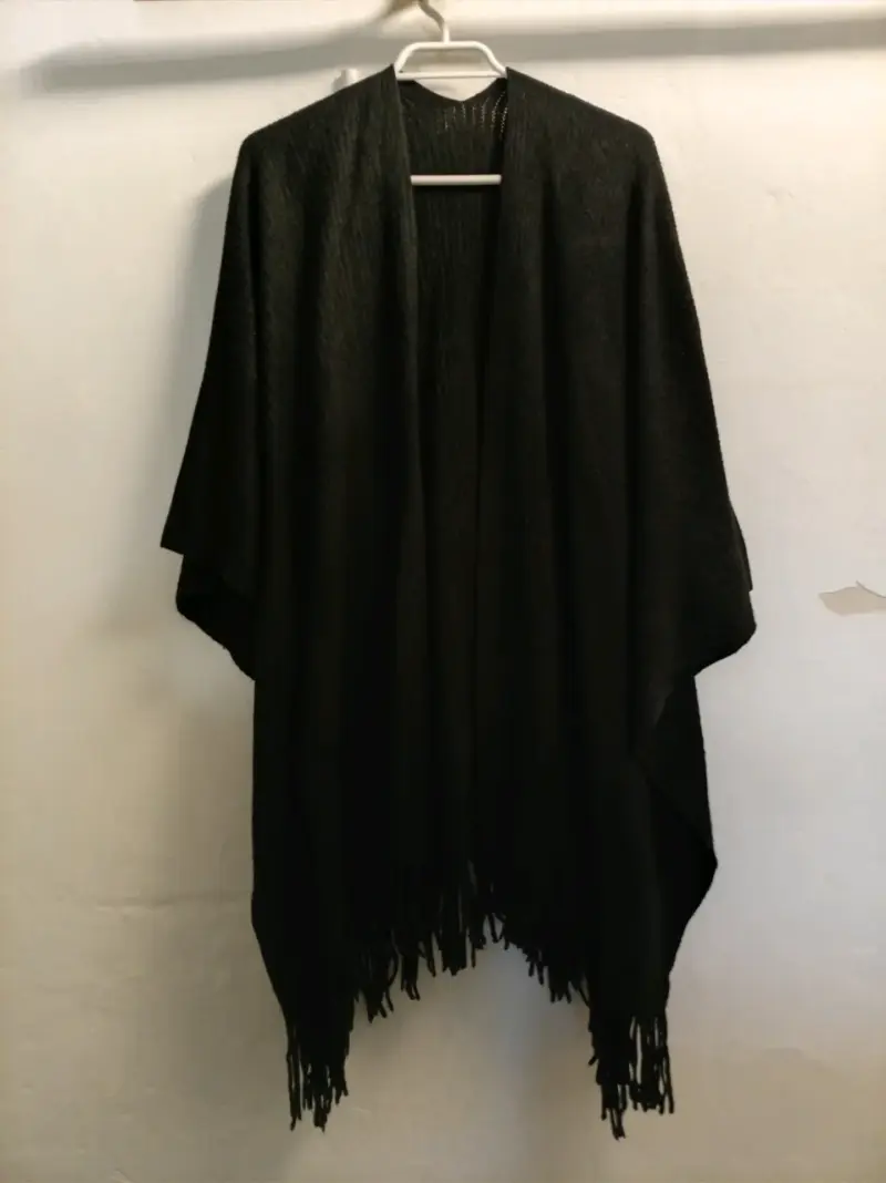 Poncho negro con flecos elegante