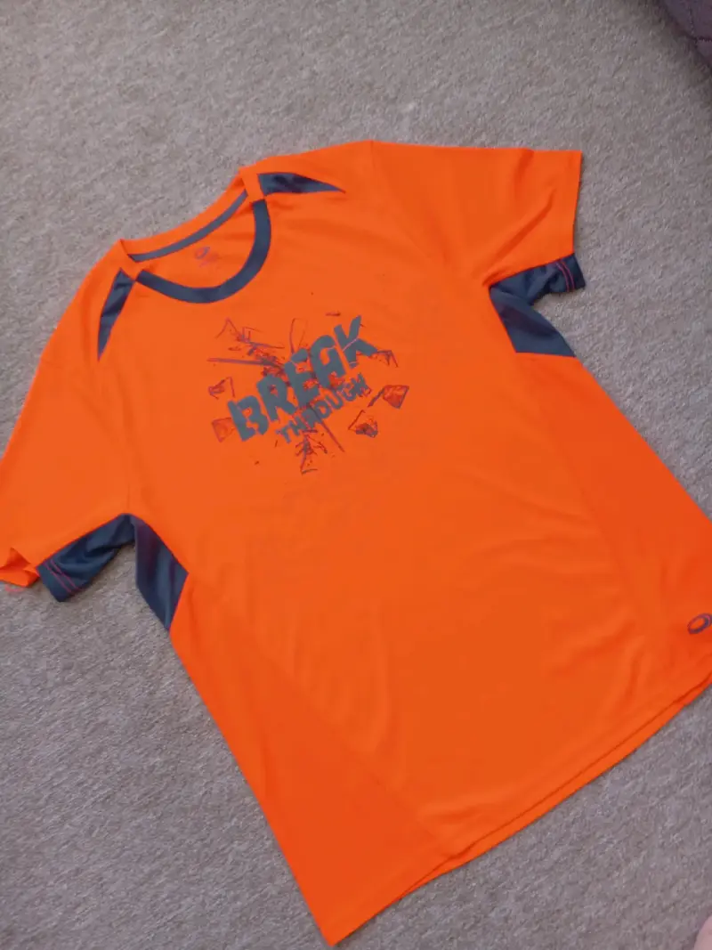 Polera deportiva naranja con diseño gráfico - 1