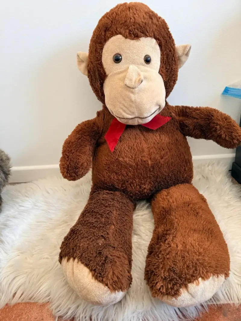 Peluche de mono grande con lazo rojo