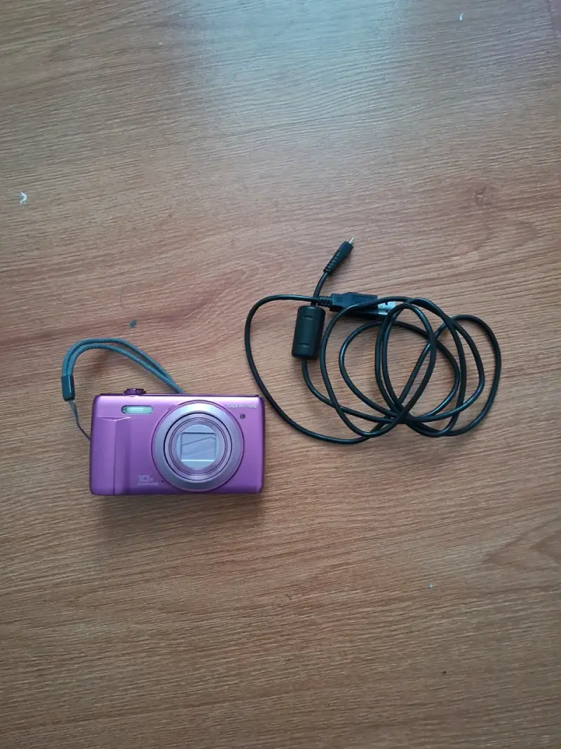 Cámara digital Olympus rosa con cable