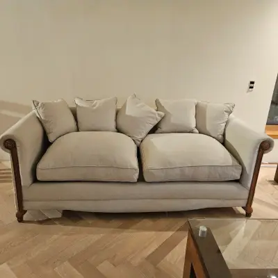 Sofá beige de tres plazas con cojines - miniatura 1