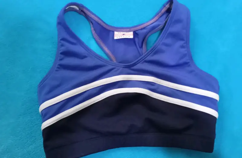 Top deportivo azul con franjas blancas