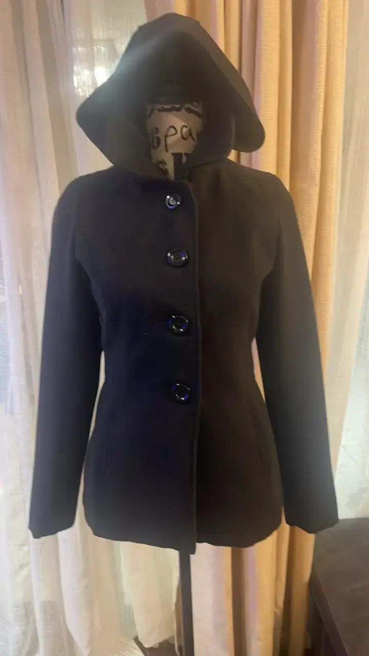 Abrigo negro con capucha y botones grandes