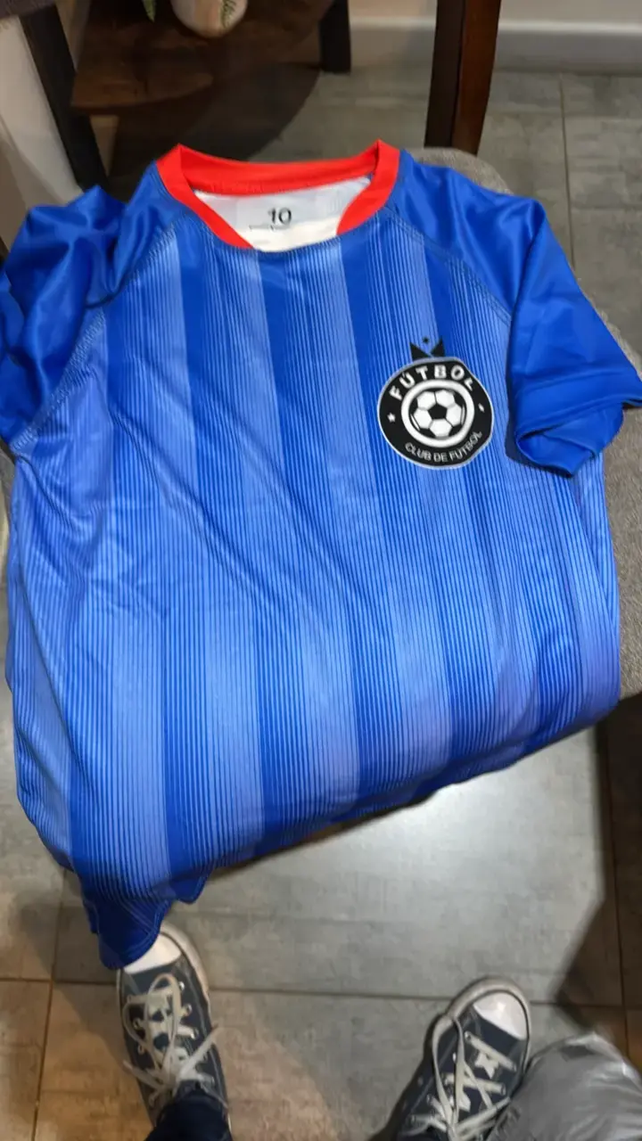 Camiseta deportiva azul con logo de fútbol