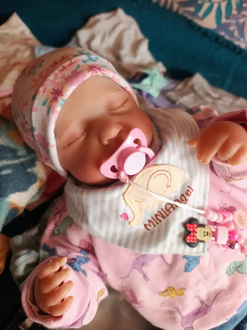 Muñeca reborn con chupete y gorro floral - 1