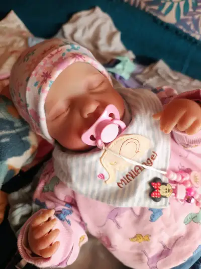 Muñeca reborn con chupete y gorro floral - miniatura 1