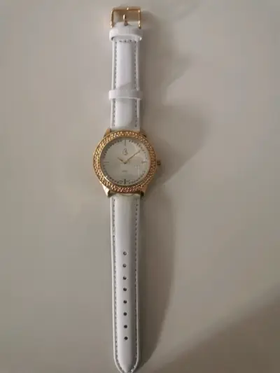 Reloj de pulsera dorado con correa blanca - miniatura 1