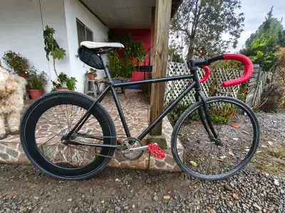 Bicicleta fixie negra con manillar rojo - miniatura 1