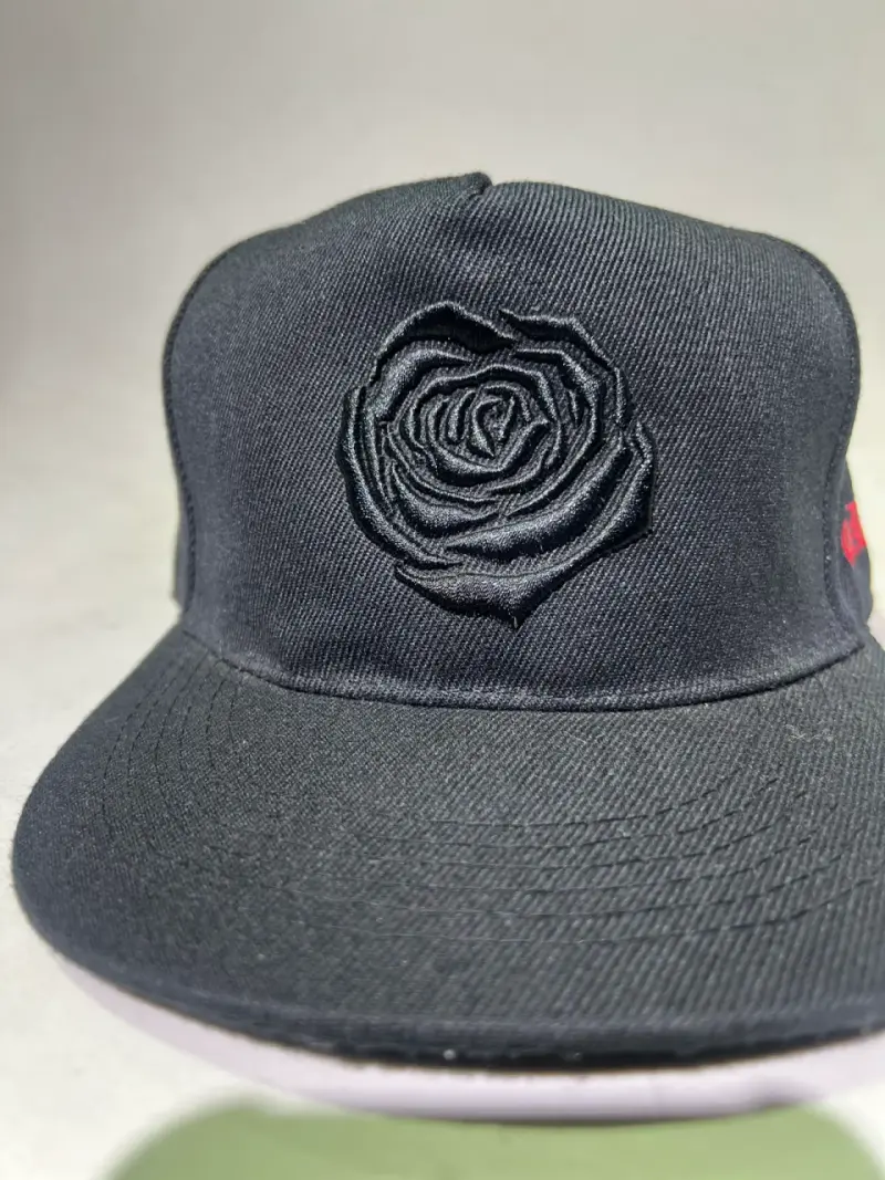 Gorra negra con diseño de rosa bordada - 1