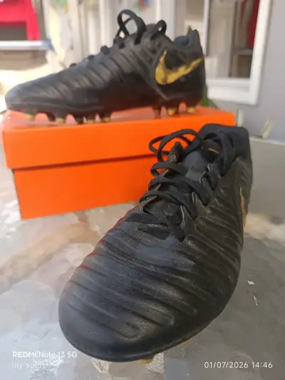 Botines de fútbol Nike negros con logo dorado - miniatura 1