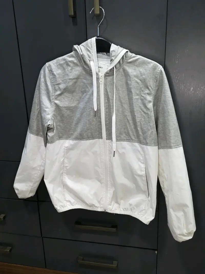 Chaqueta cortaviento gris y blanca con capucha - 1