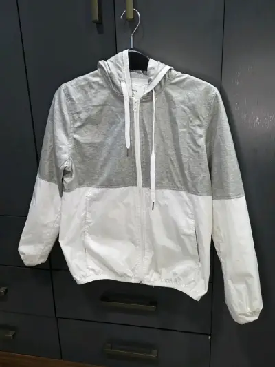 Chaqueta cortaviento gris y blanca con capucha - miniatura 1