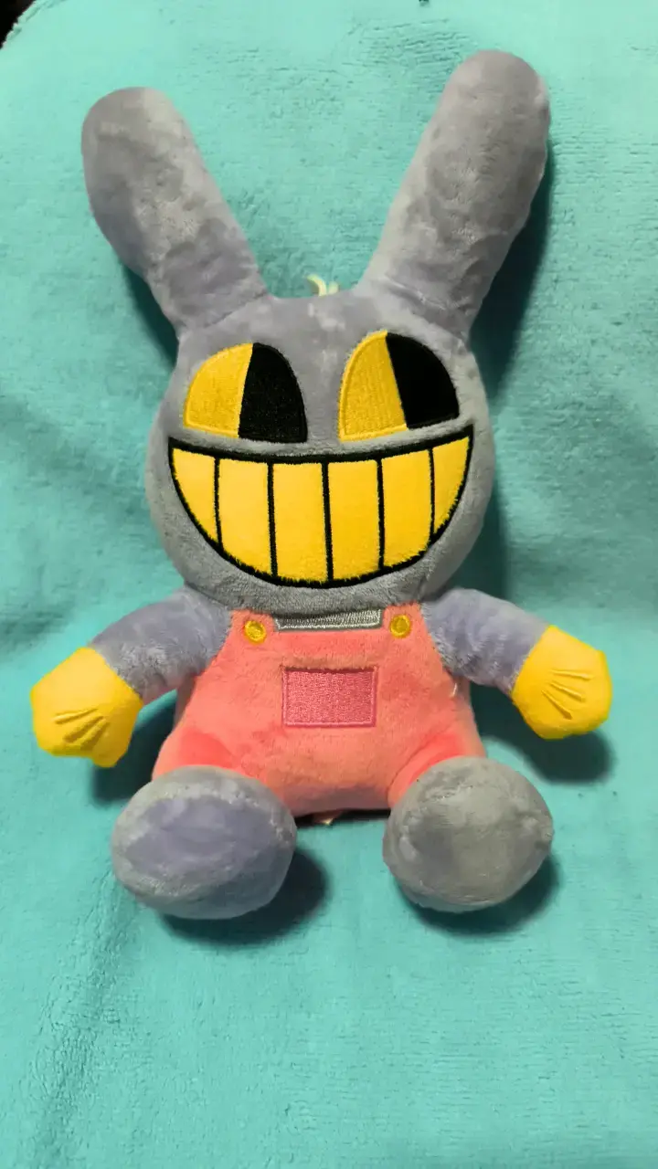 Peluche conejo gris con sonrisa amarilla