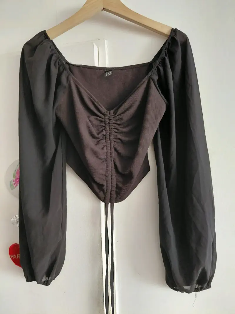 Blusa negra con mangas largas y fruncido