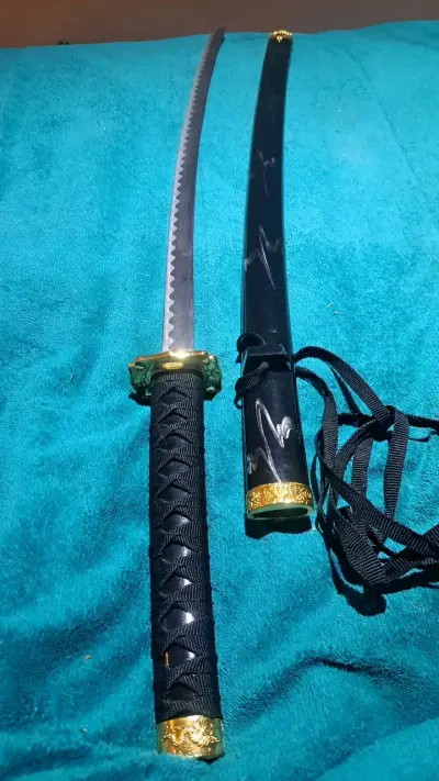 Katana decorativa con funda negra y detalles dorados - miniatura 1