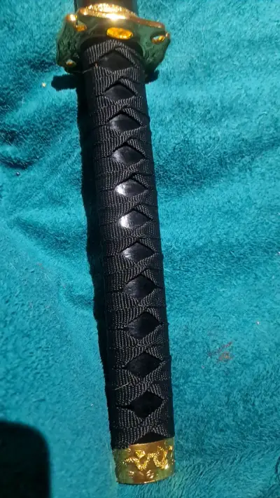 Katana decorativa con funda negra y detalles dorados - miniatura 2