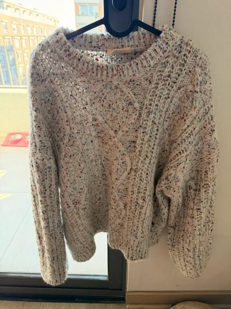 Suéter tejido beige con diseño trenzado y brillos