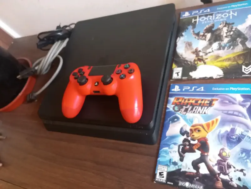 Consola PS4 con control rojo y juegos incluidos