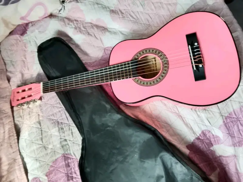 Guitarra acústica rosa con funda