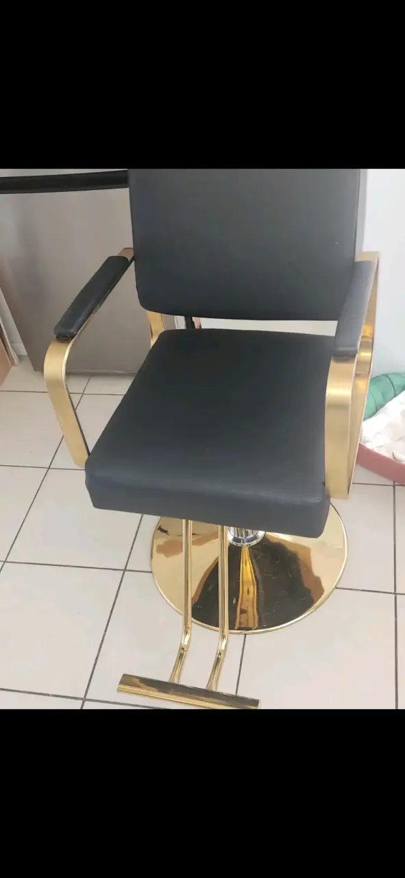 Silla de peluquería negra con base dorada