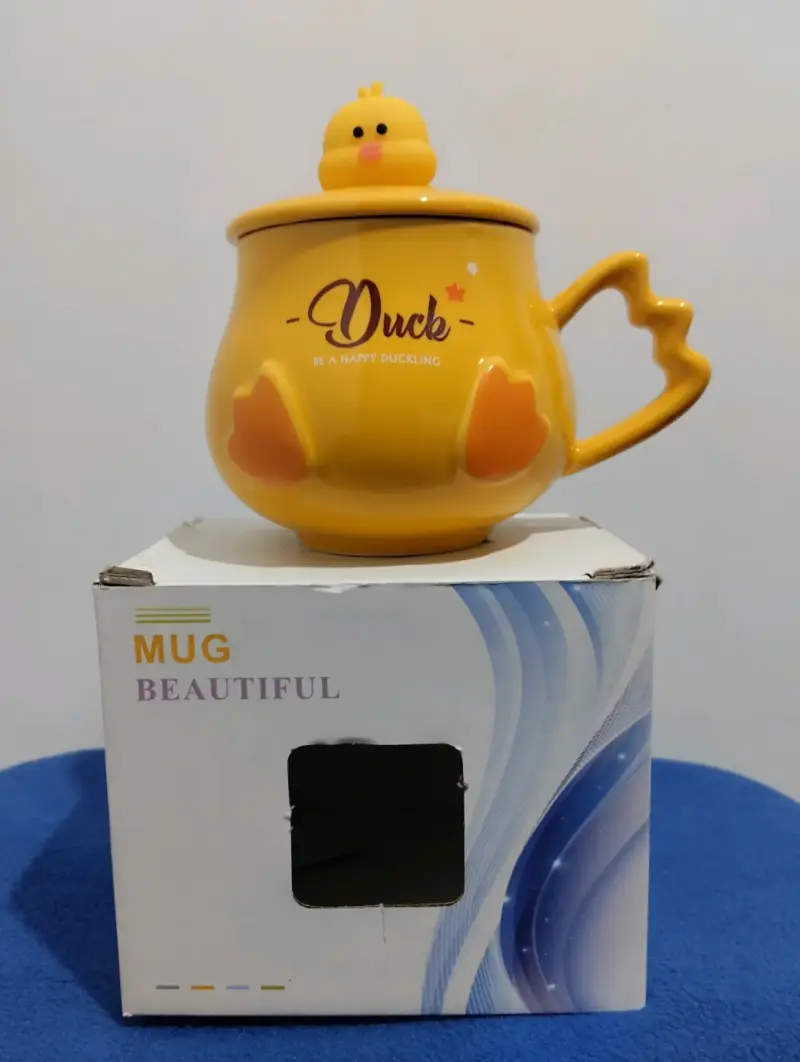 Taza de cerámica amarilla con tapa de pato