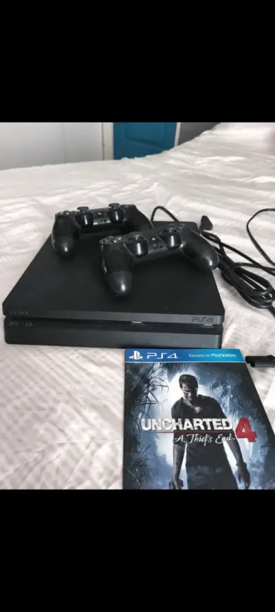 Consola PS4 con dos controles y juego Uncharted 4 - miniatura 1
