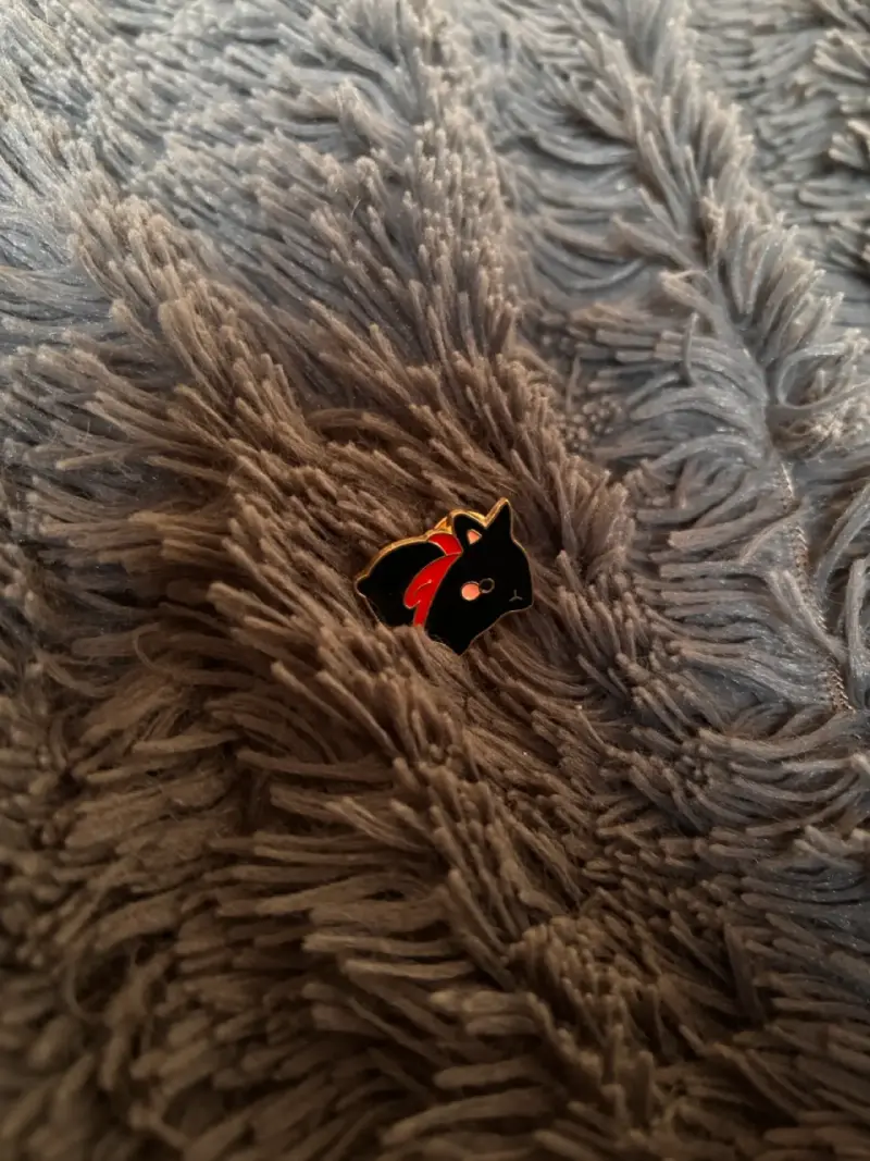 Pin de gato negro con bufanda roja