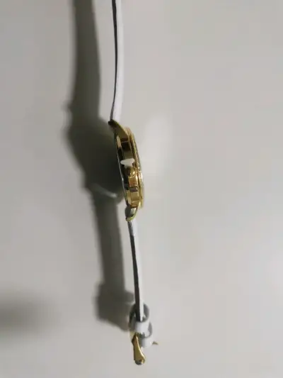 Reloj de pulsera dorado con correa blanca - miniatura 6