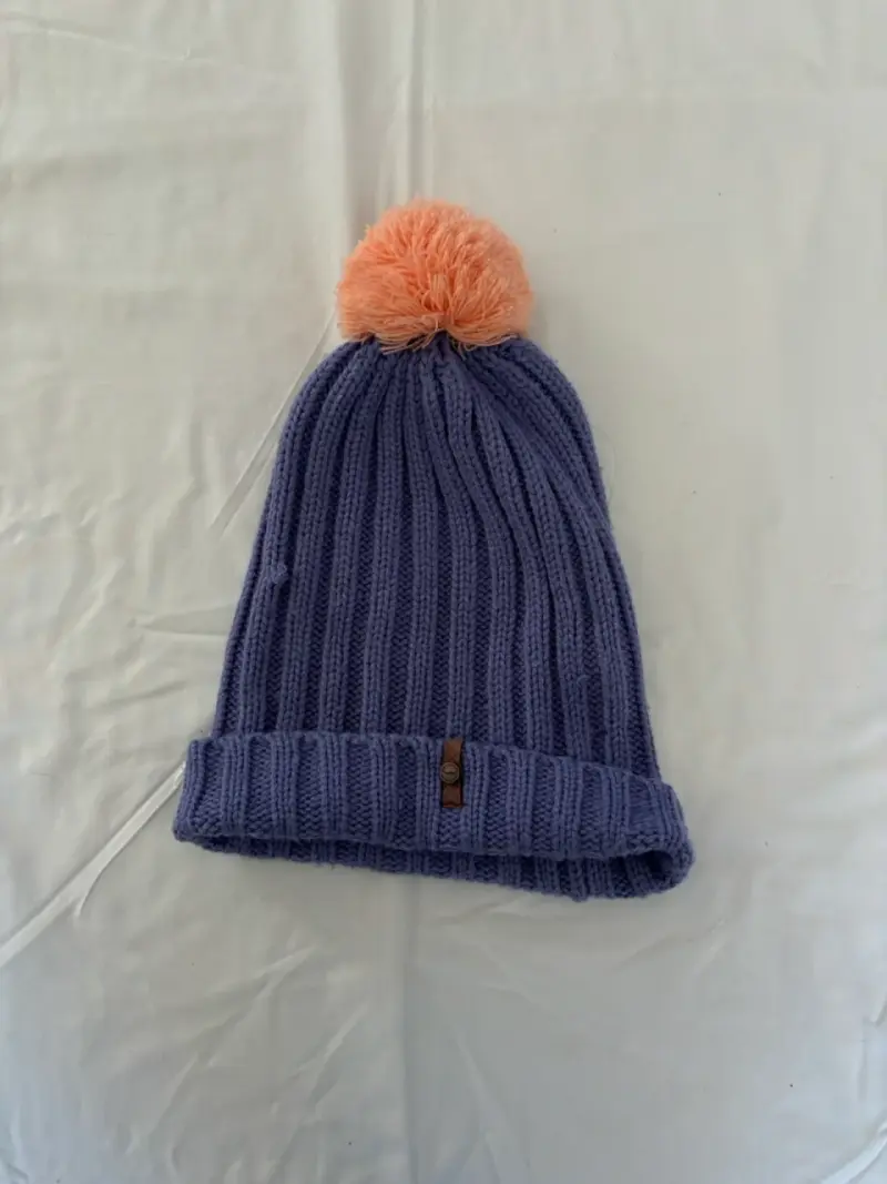 Gorro de lana morado con pompón naranja