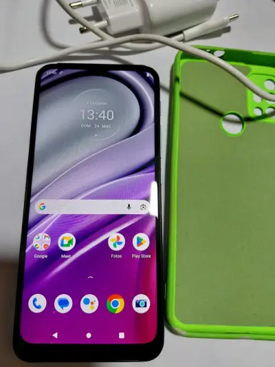 Smartphone Motorola con funda verde y cargador - miniatura 1